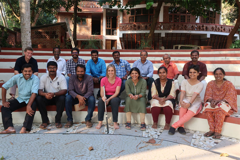 Group picture of kanthari staff sitting on amphitheatre posing for picture and all are smiling