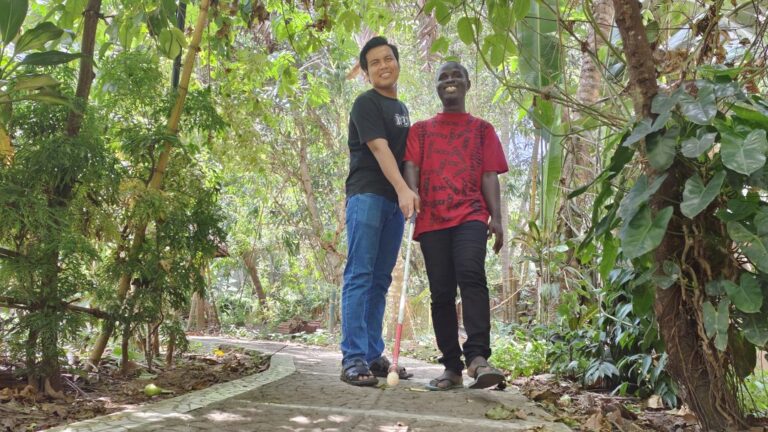 Bone from Myanmar teaches Wilfred, a blind kanthari participant in mobility skills